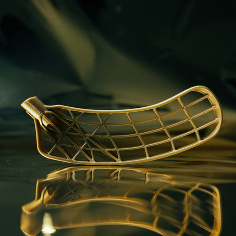 Gold floorball blade on a reflective surface with a dark background